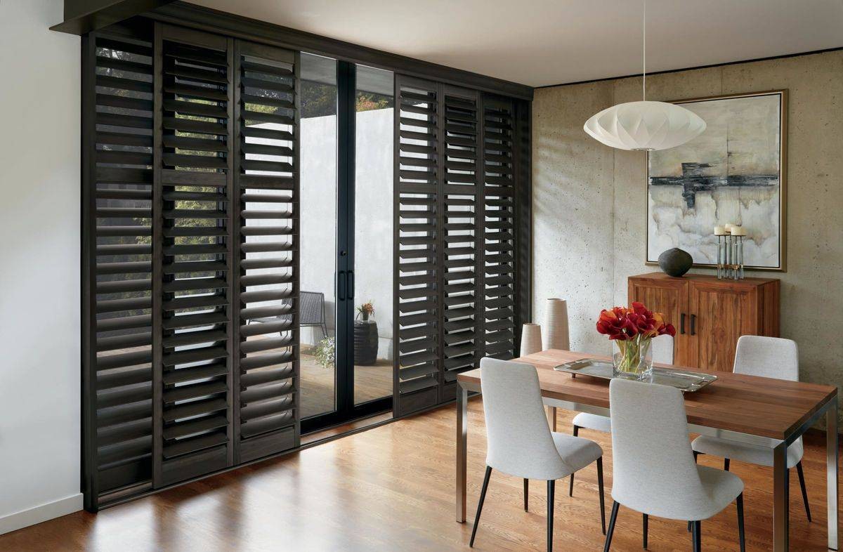 Black Hunter Douglas NewStyle® Composite Shutters adorning sliding glass doors near Rehoboth Beach, DE