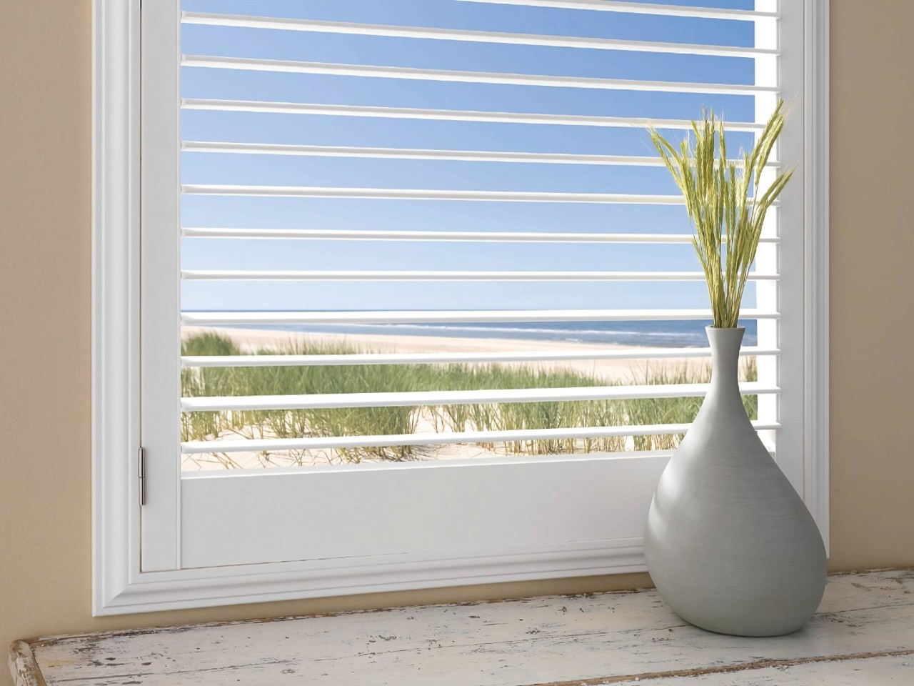 Hunter Douglas Palm Beach™ Polysatin™ Vinyl Shutters in a coastal interior design home overlooking a beach at Dreamweaver Interiors & Fabrics near Rehoboth Beach, DE